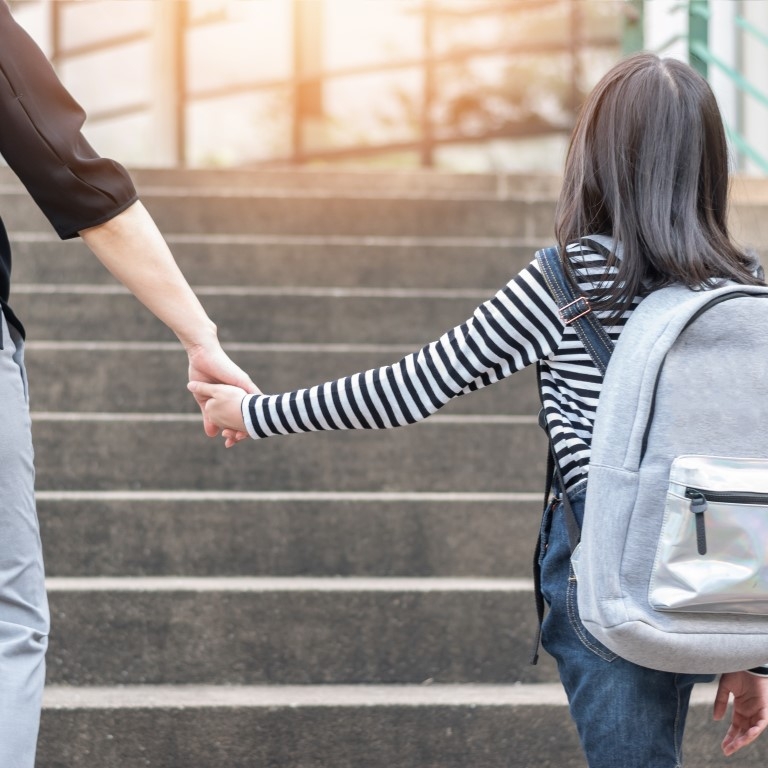 ouder kind hand in hand schooltas